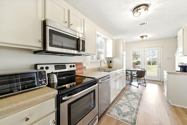 kitchen featuring light countertops, appliances with stainless steel finishes, and a sink