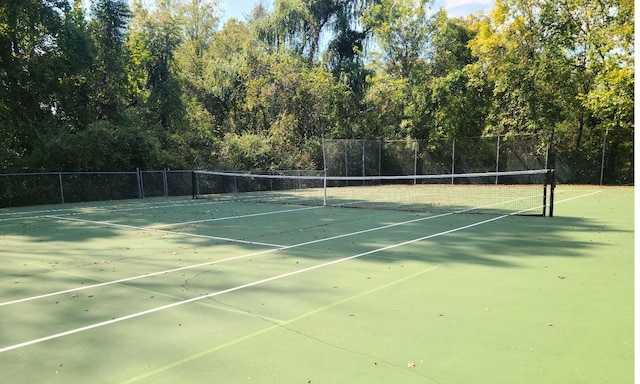 view of tennis court featuring fence