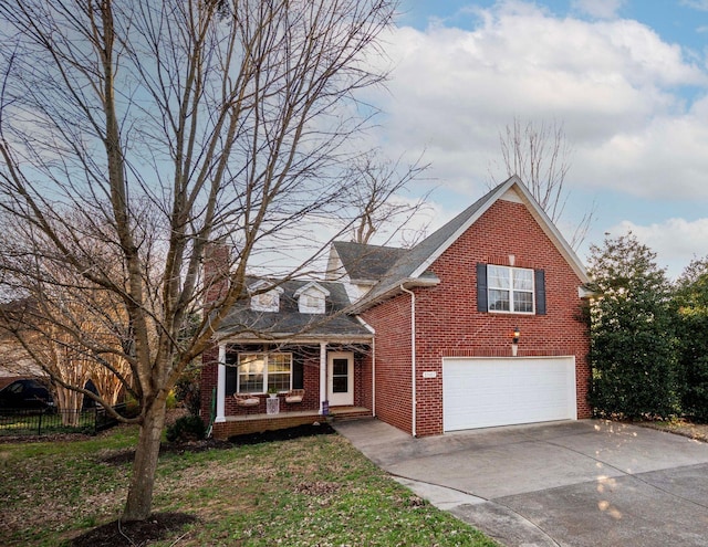 traditional-style house with fence, driveway, a front lawn, a garage, and brick siding