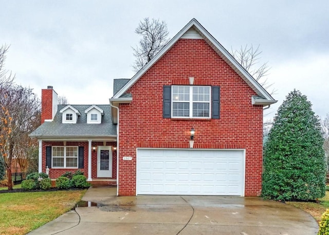 traditional home featuring an attached garage, a chimney, concrete driveway, brick siding, and a front lawn
