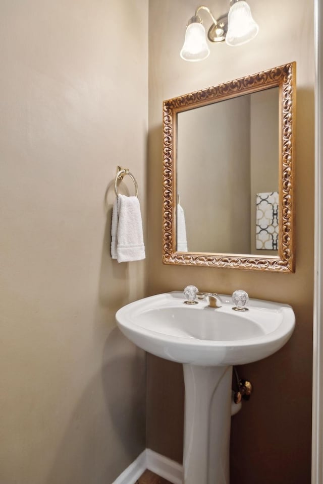 bathroom with an inviting chandelier and baseboards