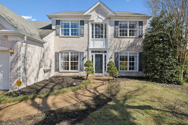 view of front of house featuring a garage, brick siding, and a front yard