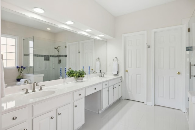 bathroom featuring a sink, double vanity, a shower stall, and tile patterned floors