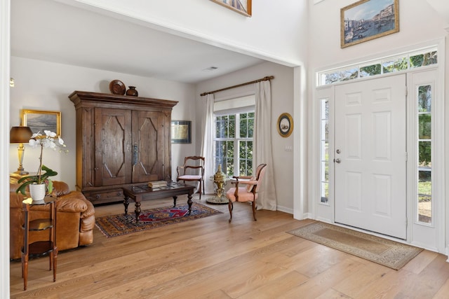 foyer featuring visible vents, light wood-type flooring, and baseboards