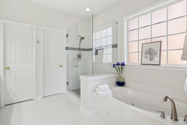 bathroom with a tub with jets, a stall shower, and a healthy amount of sunlight