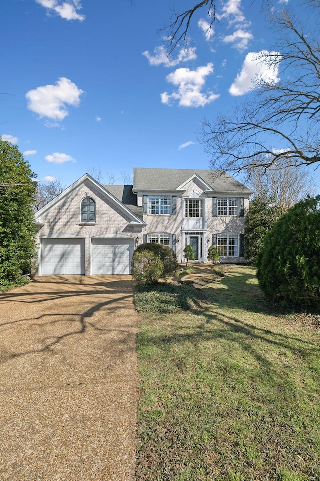 view of front facade featuring a garage, concrete driveway, and a front yard