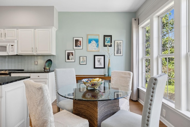 dining space featuring a healthy amount of sunlight, baseboards, and wood finished floors