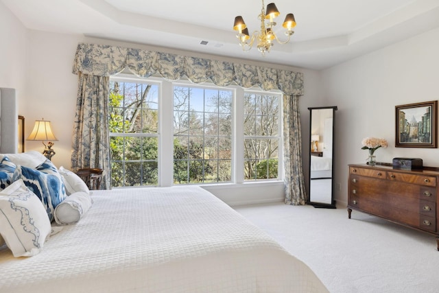 bedroom with a notable chandelier, visible vents, a tray ceiling, and carpet floors