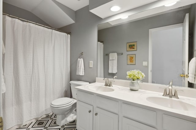 bathroom with a sink, toilet, and double vanity