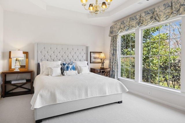 bedroom with a tray ceiling, carpet flooring, baseboards, and a chandelier