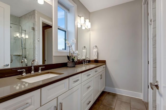 bathroom featuring a marble finish shower, tile patterned floors, baseboards, and a sink