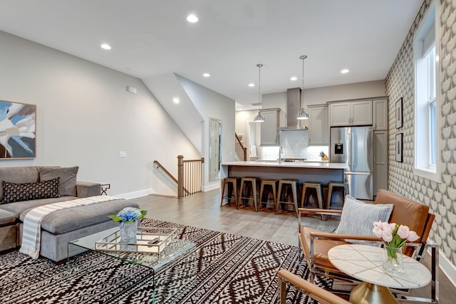 living room with recessed lighting, baseboards, and light wood-style floors