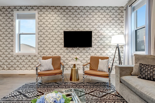 living area with wood finished floors, a healthy amount of sunlight, baseboards, and visible vents