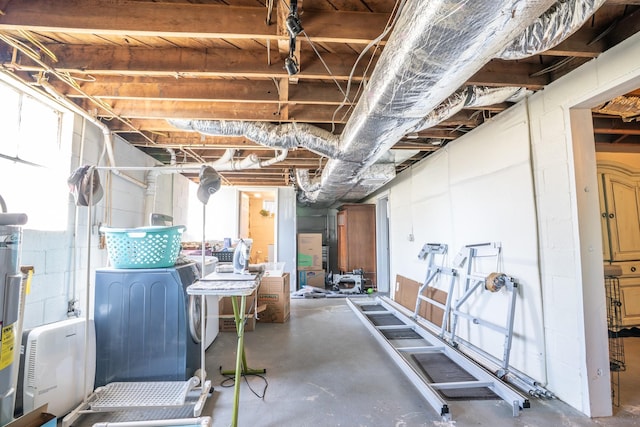 basement featuring washing machine and dryer and concrete block wall