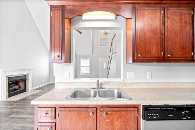 kitchen featuring dishwashing machine, wood finished floors, a sink, an AC wall unit, and light countertops