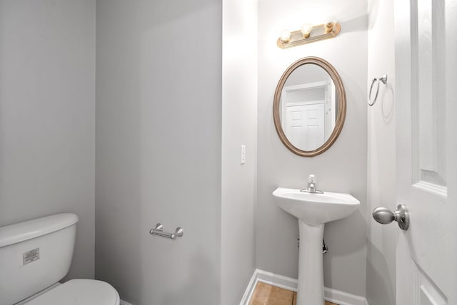 bathroom featuring toilet and baseboards