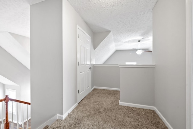 bonus room featuring baseboards, carpet, lofted ceiling, a textured ceiling, and a ceiling fan