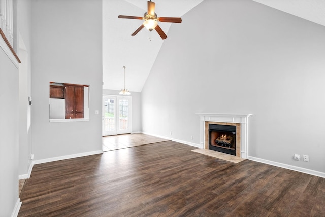 unfurnished living room featuring baseboards, wood finished floors, a ceiling fan, and a tile fireplace