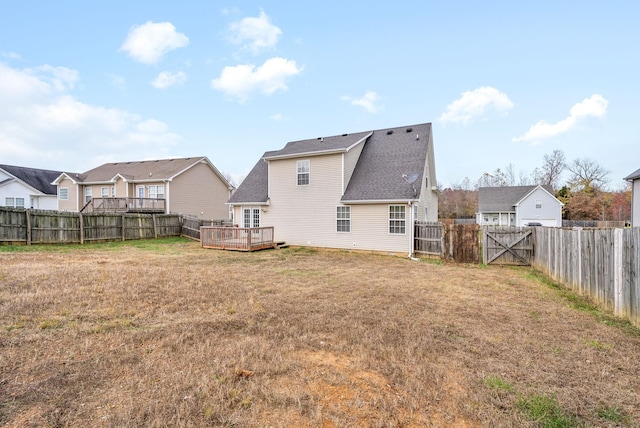 rear view of house featuring a wooden deck, a residential view, a lawn, and a fenced backyard