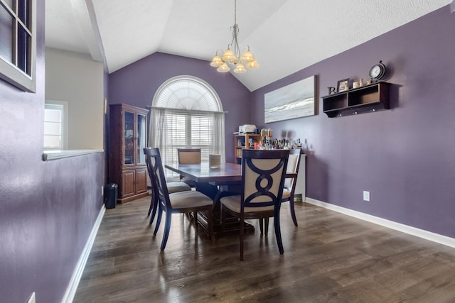 dining space featuring baseboards, lofted ceiling, a notable chandelier, and wood finished floors