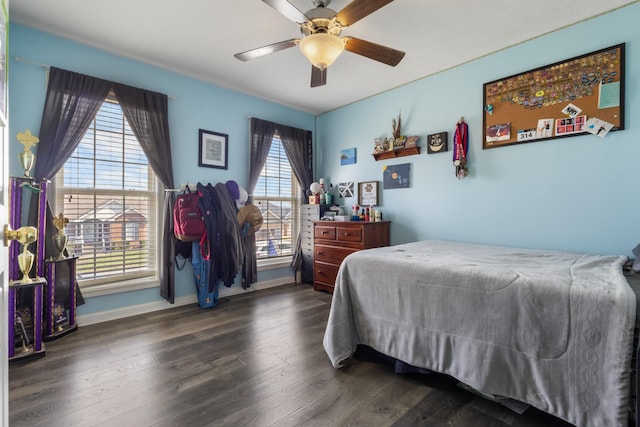 bedroom featuring wood finished floors, baseboards, and ceiling fan