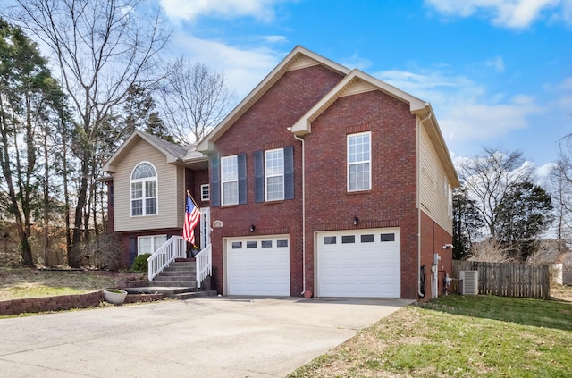 split foyer home with cooling unit, fence, concrete driveway, a garage, and brick siding