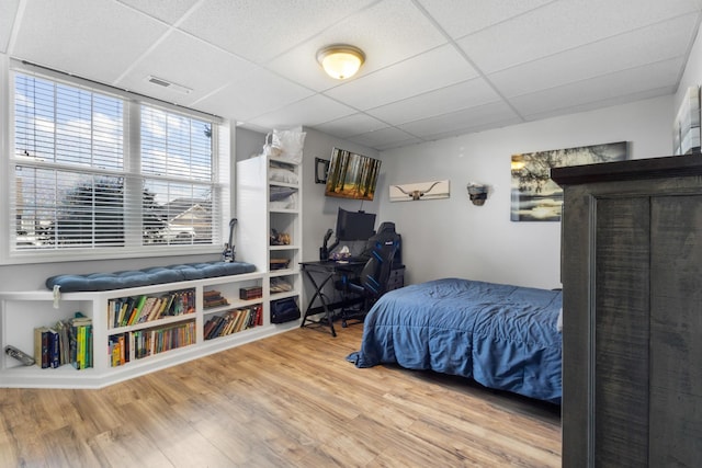 bedroom with visible vents, a paneled ceiling, and wood finished floors