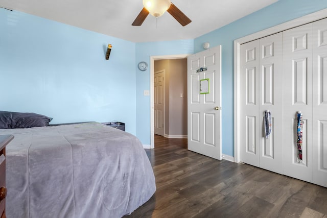 bedroom with a closet, baseboards, dark wood-style floors, and a ceiling fan