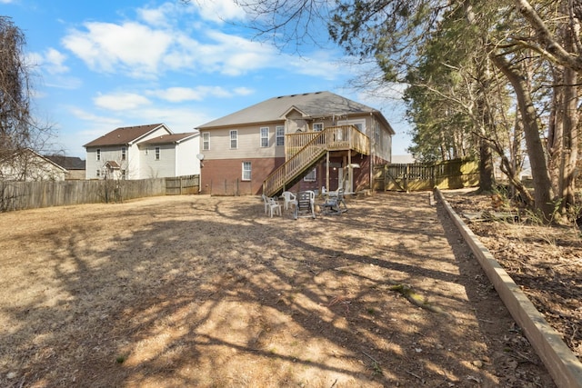 back of house featuring stairs, a deck, and a fenced backyard