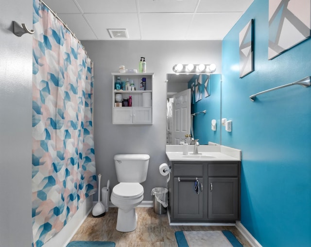 full bathroom featuring visible vents, curtained shower, toilet, vanity, and a paneled ceiling