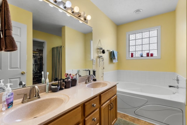 full bathroom with a sink, a walk in closet, a bath, and double vanity