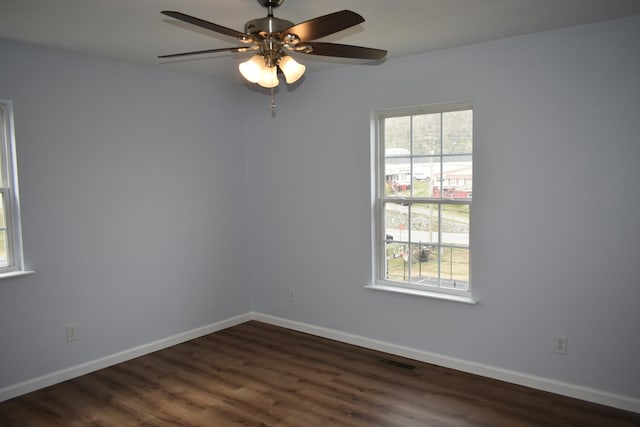 empty room with a wealth of natural light, visible vents, and baseboards