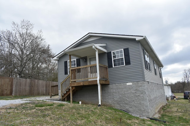 view of front of property with stairway, covered porch, and fence