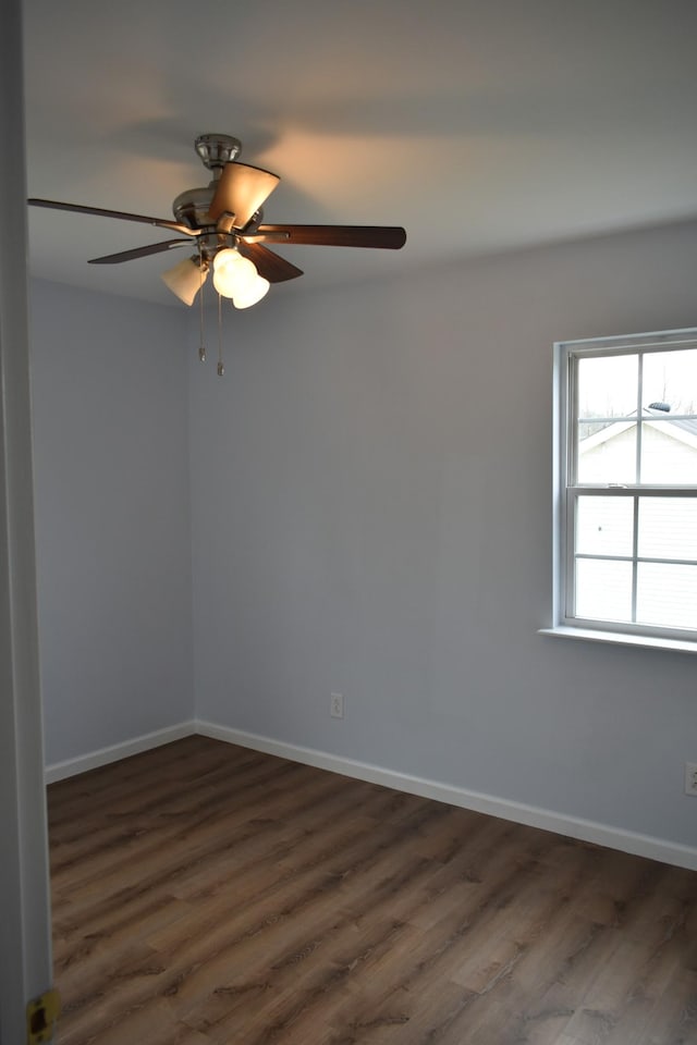 empty room featuring dark wood-style floors, baseboards, and a ceiling fan