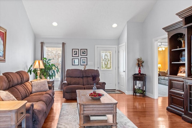 living room with lofted ceiling, wood finished floors, recessed lighting, baseboards, and ceiling fan