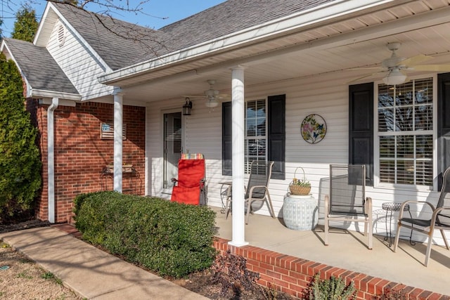 property entrance with brick siding, covered porch, roof with shingles, and ceiling fan