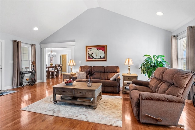 living area with a notable chandelier, wood finished floors, recessed lighting, and high vaulted ceiling