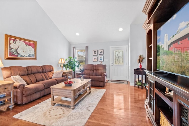 living area featuring recessed lighting, baseboards, lofted ceiling, and light wood-style floors