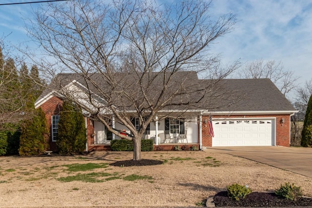 view of front of property with driveway, brick siding, covered porch, and an attached garage