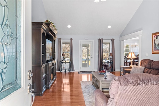 living area with recessed lighting, baseboards, lofted ceiling, and light wood-style flooring