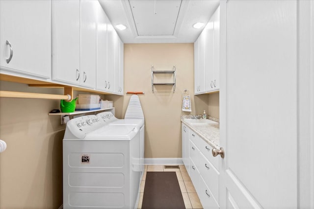 laundry room with baseboards, light tile patterned floors, cabinet space, independent washer and dryer, and a sink