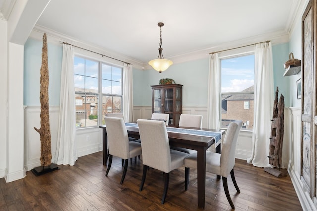 dining area with a decorative wall, dark wood-style floors, a wainscoted wall, and ornamental molding