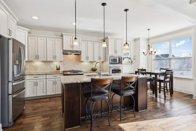 kitchen featuring a sink, decorative backsplash, ornamental molding, stainless steel appliances, and under cabinet range hood