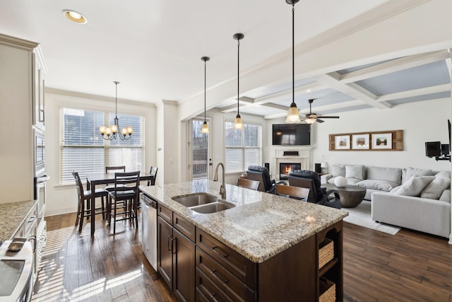 kitchen with a sink, coffered ceiling, a glass covered fireplace, dark brown cabinetry, and appliances with stainless steel finishes