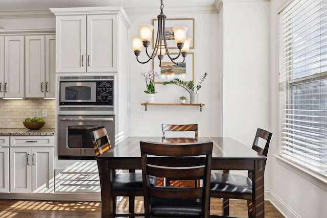 dining space with a healthy amount of sunlight, a chandelier, and crown molding