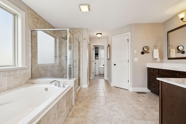 bathroom with a garden tub, a spacious closet, a stall shower, and vanity