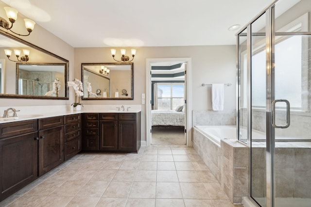 full bath featuring a notable chandelier, a sink, a shower stall, tile patterned flooring, and double vanity