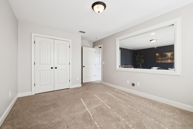 unfurnished bedroom with visible vents, baseboards, carpet, and a closet