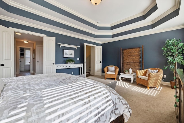 carpeted bedroom featuring a tray ceiling, baseboards, and ornamental molding