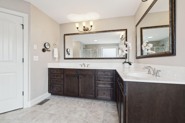 full bathroom featuring double vanity, a notable chandelier, a stall shower, and a sink